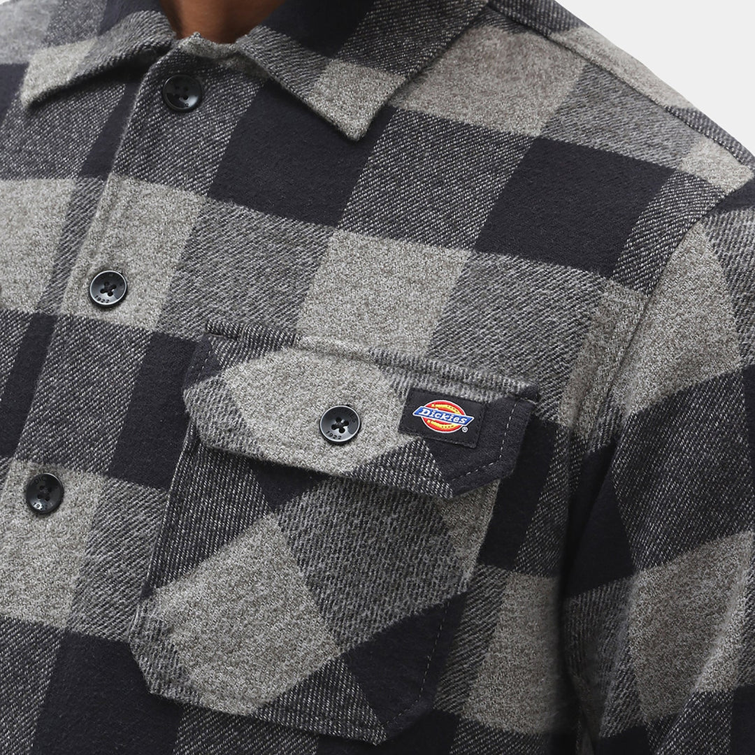 Close-up of a checkered shirt with Dickies logo on a pocket