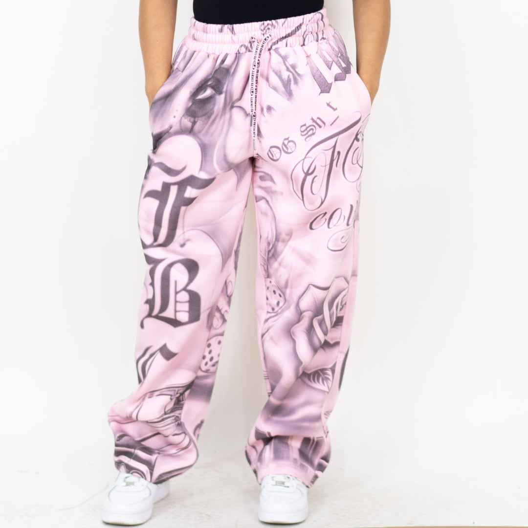 Pink sweatpants with graphic design and text on a white background